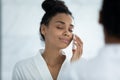 Head shot relaxed African American woman using facial cleansing sponge Royalty Free Stock Photo