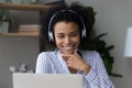 Head shot smiling African American woman in headphones using laptop Royalty Free Stock Photo