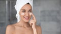 Head shot smiling beautiful woman with perfect skin applying cream Royalty Free Stock Photo