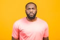 Head shot studio portrait over yellow blank isolated dark-skinned sad man wearing white t-shirt feels frustrated and unhappy