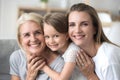 Three diverse generation daughter granddaughter and grandmother looking at camera Royalty Free Stock Photo