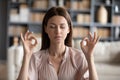 Tranquil mindful young woman managing stress at workplace. Royalty Free Stock Photo