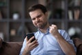 Head shot of unhappy angry man having problem with smartphone