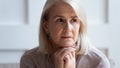 Head shot unhappy upset older woman thinking about problems