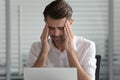 Head shot unhappy young male employee suffering from strong headache. Royalty Free Stock Photo