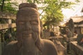 Head shot of a wise man stone statue in Asian style. Statue in Buddhist graveyard in the complex of Fushimi-Inari Shrine in Kyoto Royalty Free Stock Photo