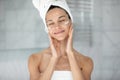 Happy beautiful young hispanic woman applying moisturizing creme. Royalty Free Stock Photo