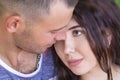 Head shot of a young affectionate romantic couple of lovers. Close up portrait of an attractive brunette girl and guy with closed