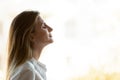 Head shot young mindful businesswoman breathing fresh air.