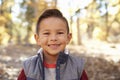 Head and shoulders portrait of a Hispanic boy in a forest