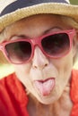 Head And Shoulders Portrait Of Senior Woman Poking Out Tongue Royalty Free Stock Photo