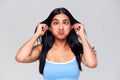 Head And Shoulders Studio Shot Of Woman Pulling Faces And Smiling At Camera