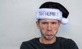 Pouting Caucasian man in a black and white Bah Humbug hat Royalty Free Stock Photo