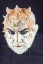 Head with thorns or warts, face covered with glitters, close up. Alien, demon, sorcerer makeup. Fantasy concept. Demon