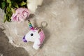 Head of a unicorn key chain top view with peonies