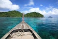 head of wooden boat on transparent blue sea