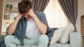 Headache attack migraine man blanket couch home