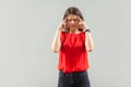 Headache, confution or thinking. Portrait of serious beautiful brunette young woman in red shirt standing and holding her painful