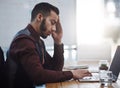 This headache is just the most frustrating. a young businessman looking stressed out while working in an office. Royalty Free Stock Photo