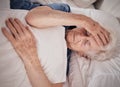 Headache, pain and senior woman in bed for trauma recovery, rehabilitation or rest in elderly care nursing home Royalty Free Stock Photo