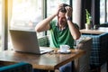 Headache, problem or confusion! Young businessman in green t-shirt sitting and holding his painful head. business and freelancing Royalty Free Stock Photo