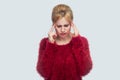 Headache, sadness, confusion or concentration. Portrait of worry alone beautiful young blond woman in red blouse standing, holding