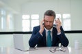 Headache, tiredness and stress. Business man in suit uses a laptop, is tired got headache migraine. Headache pain Royalty Free Stock Photo