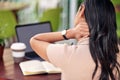 Headaches are real setbacks. Rearview shot a young florist experiencing neck pain while using her laptop at work.