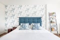 Headboard upholstered in blue capitone fabric with matching cushions