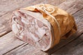Headcheese closeup on table tied with twine and wrapped in paper Royalty Free Stock Photo