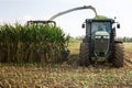 Header harvesting fodder corn mass, pouring into truck body