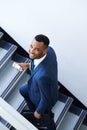 Heading to the office. A handsome african american businessman using his smartphone while walking up the stairs. Royalty Free Stock Photo