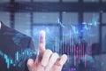 Headless busiessman pointing at glowing candlestick forex chart on blurry office iterior background. Investment, profit and Royalty Free Stock Photo