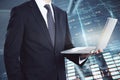 Headless businessman holding laptop on abstract glowing forex background. Royalty Free Stock Photo