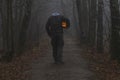 Headless man with Halloween pumpkin in foggy forest