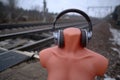 Headless mannequin in headphones near the railroad tracks Royalty Free Stock Photo