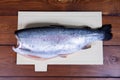 A headless peeled trout lies on a chopping Board