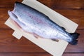 A headless peeled trout lies on a chopping Board