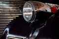 The headlight of an antique, rarity, vintage black car