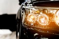 Headlight lamp of the new black luxury car, Close up detail on one of the LED headlights with flare of modern car. Royalty Free Stock Photo