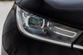 Headlight lamp of new cars. Close up detail on one of the LED headlights modern black car. Exterior closeup detail. Royalty Free Stock Photo