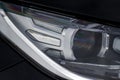Headlight lamp of new cars. Close up detail on one of the LED headlights modern black car. Exterior closeup detail. Royalty Free Stock Photo