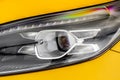 Headlight lamp of new cars. Close up detail on one of the LED headlights modern yellow car. Exterior closeup detail. Closeup headl