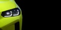 Headlight with LED xenon light of modern light green EV Car on black color background Royalty Free Stock Photo