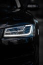 Headlight of Modern Prestigious Black Car Close Up. Royalty Free Stock Photo