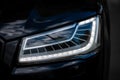 Headlight of Modern Prestigious Black Car Close Up. Royalty Free Stock Photo