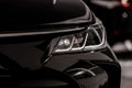 Headlight of modern prestigious black car close up. Close up photo of modern car, detail of headlight. Headlight car Projector LED Royalty Free Stock Photo