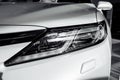 Headlight of modern prestigious white car close up. Close up photo of modern car, detail of headlight. Headlight car Projector LED Royalty Free Stock Photo