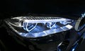 Headlight of a modern sport car. Front view of luxury sport car. Car exterior details. The front lights of the car.
