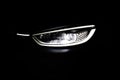 Headlight turning off switching of car LED headlights in night. New modern electric car headlamp. Close up of car front